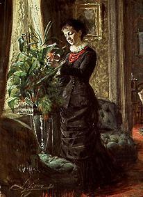 Mme Lisen Samson arrangeant les fleurs devant une fenêtre