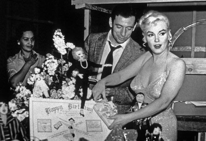 French Actor Yves Montand, American Actress Marilyn Monroe and a birthday cake. à Photographies de Célébrités
