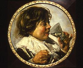 portrait d'un garçon riant avec un verre de vin