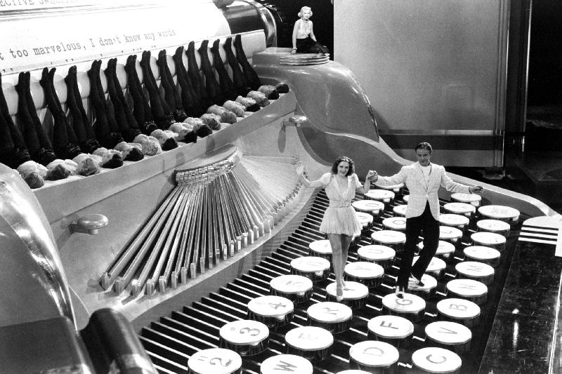Couple dancing on the key of a giant typewriter, keys are leg of dancers, musical à 
