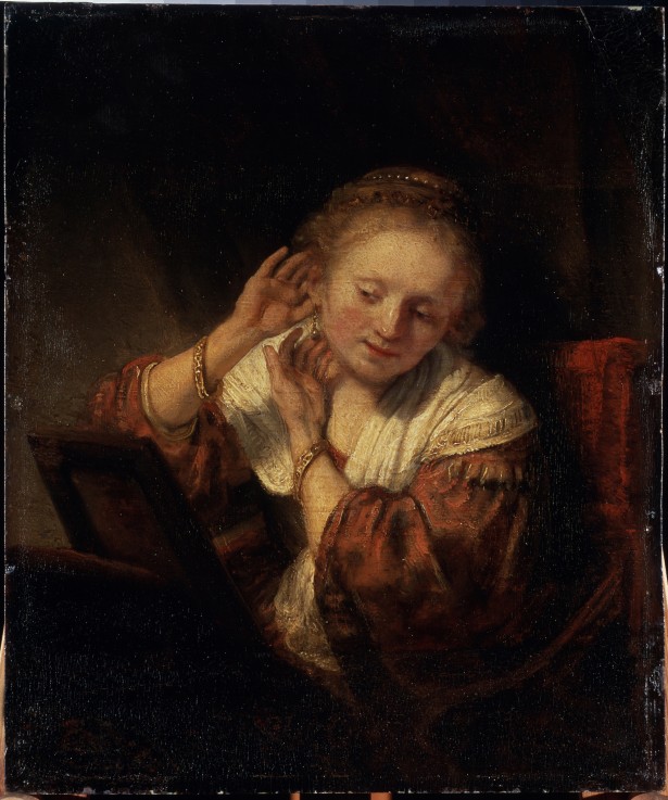 Young Woman trying on Earrings à Rembrandt Harmenszoon van Rijn